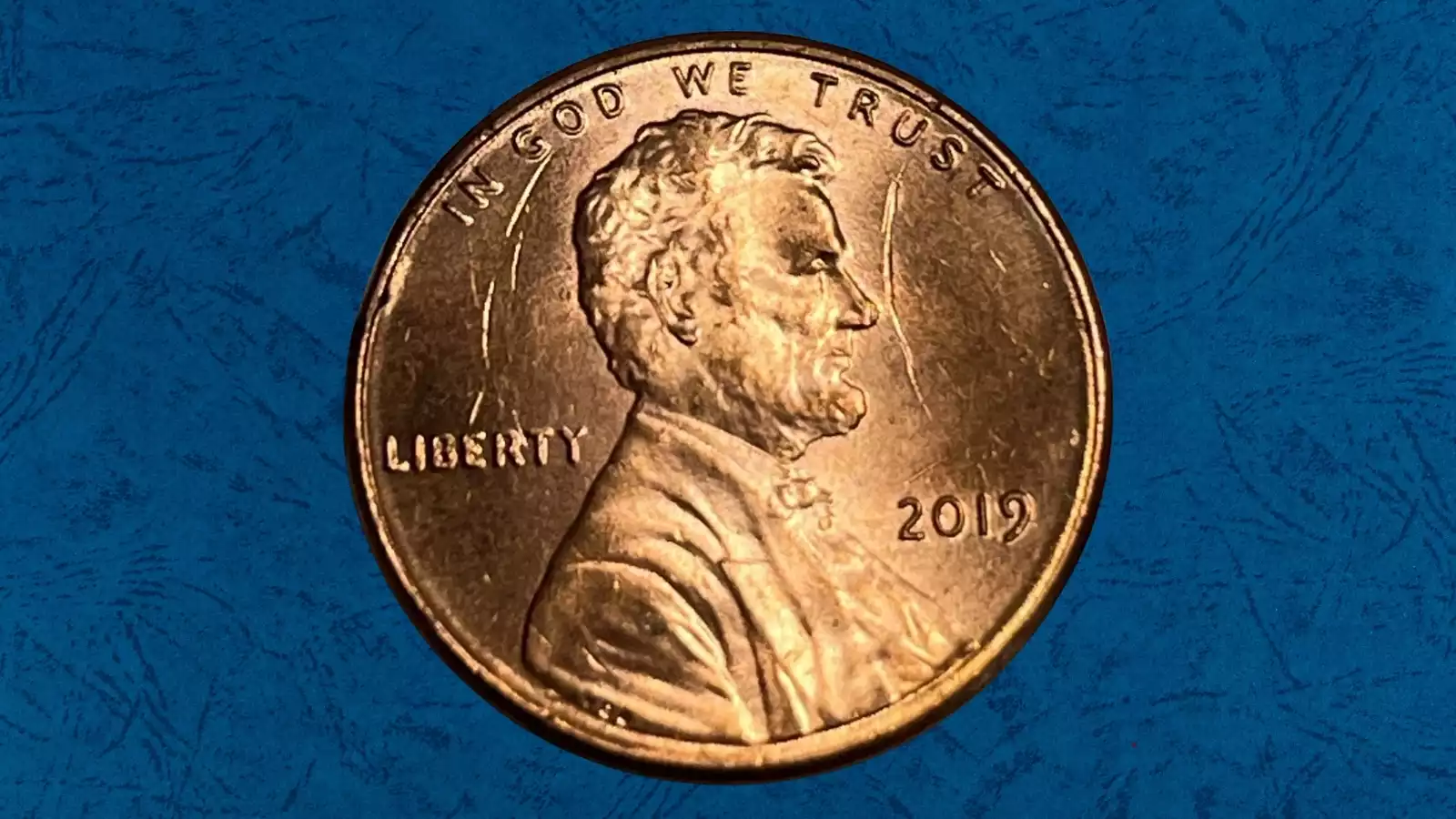 2019 Lincoln penny obverse showing a raised die cud error on the rim with a connecting die crack visible